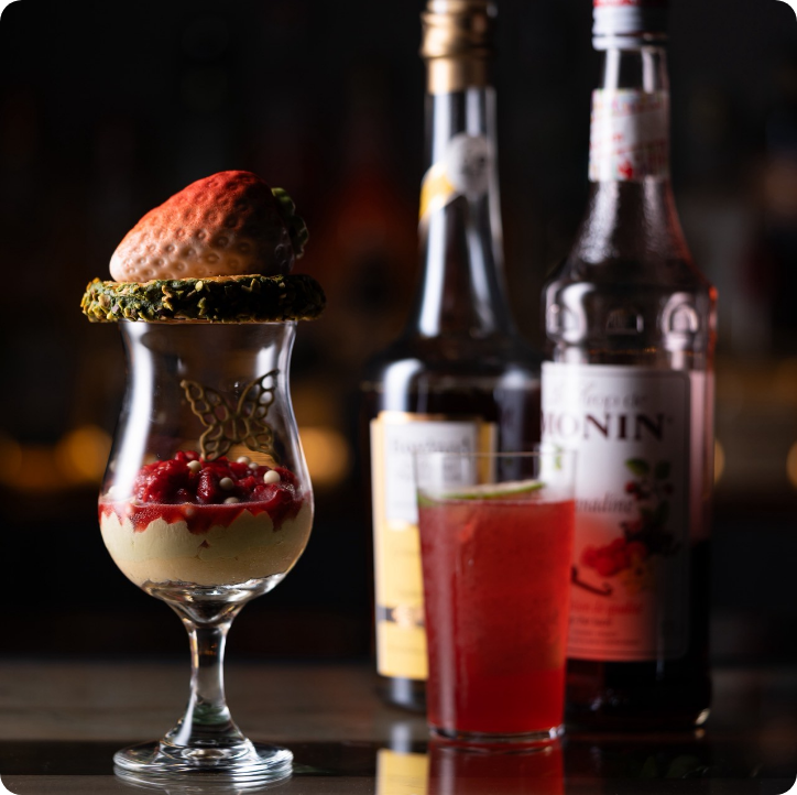 大粒いちごとピスタチオリングが印象的なパフェ。甘酸っぱいベリーソースとカクテルのマリアージュ